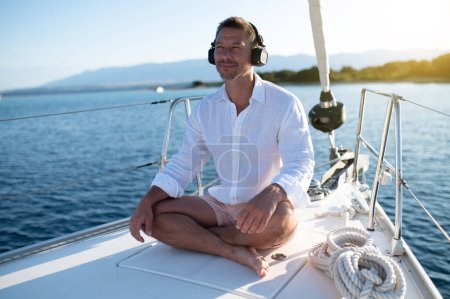 Photo for Meditation on a yacht. Man sitting in a lotus pose and meditating - Royalty Free Image