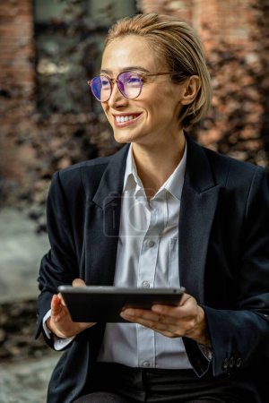 Photo for Communication. Cute young woman in eyeglasses with a tablet in hands - Royalty Free Image