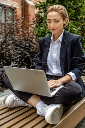 Photo for Work balance. Young business woman sitting in a lotus pose and working on laptop - Royalty Free Image