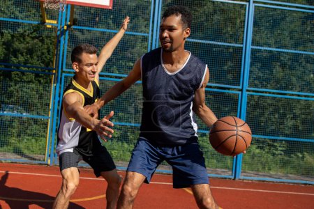 Foto de Dos jugadores de baloncesto callejeros entrenando al aire libre en la cancha. - Imagen libre de derechos