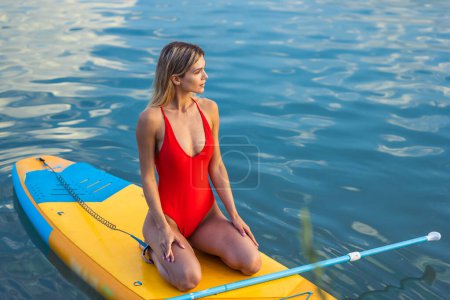 Téléchargez les photos : Belle femme blonde sur SUP board en vacances d'été. - en image libre de droit
