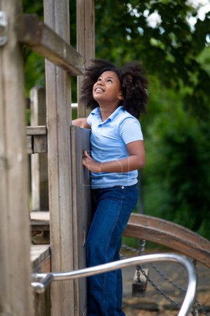 Photo for Playing in the park. Cute african american girl playing outside and looking contented - Royalty Free Image