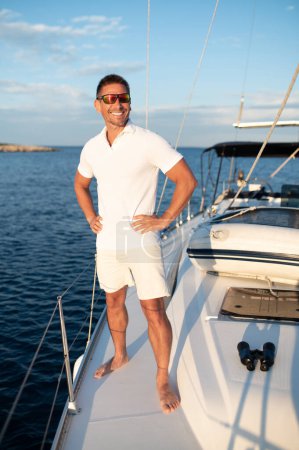 Photo for Good life. Confident handosme man in sunglasses on a yacht - Royalty Free Image
