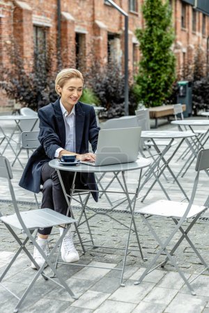 Photo for Business woman. Young pretty business woman sitting at cafe and working on laptop - Royalty Free Image
