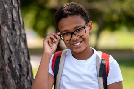 Photo for Happy boy. Dark-skinned boy in eyeglasses looking contented and happy - Royalty Free Image