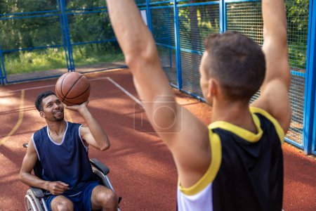 Photo for Wheelchair athlete adult man and friend savoring dynamic outdoor basketball. - Royalty Free Image