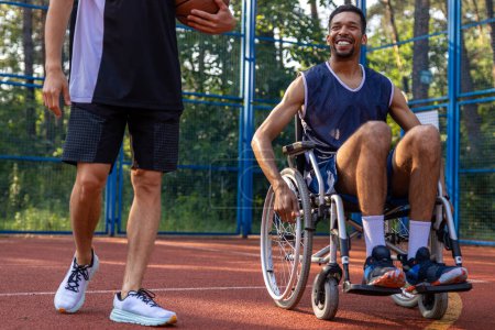 Photo for Unidentified man in wheelchair after playing friendly basketball game with his friend. - Royalty Free Image