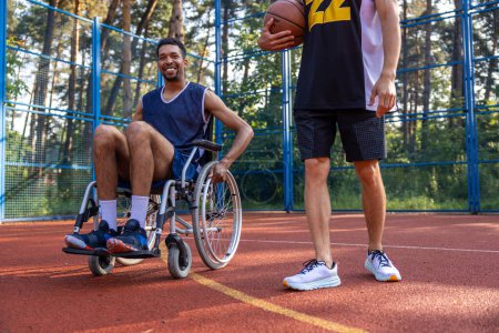 Téléchargez les photos : Homme non identifié en fauteuil roulant après avoir joué à un match de basket amical avec son ami. - en image libre de droit