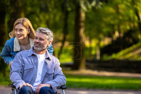 Foto de En el parque. Feliz pareja sonriente en un paseo por el parque - Imagen libre de derechos