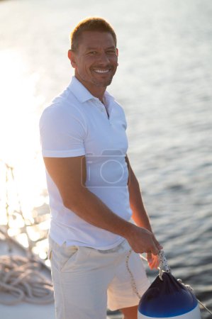 Téléchargez les photos : Yachting. Homme en vêtements blancs fixant des cordes sur un yacht - en image libre de droit