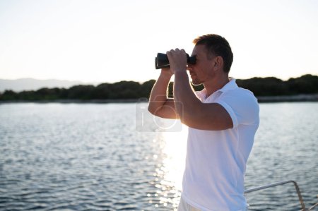 Téléchargez les photos : Aventure. Homme avec position binoculaire sur un pont de yacht - en image libre de droit