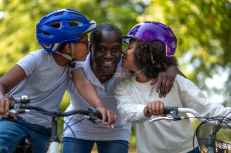 Photo for Family weekend. African american family having good time in a park and riding bikes - Royalty Free Image