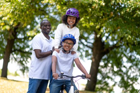 Téléchargez les photos : Bonne famille. Bonne famille en vélo dans un parc et s'amuser ensemble - en image libre de droit