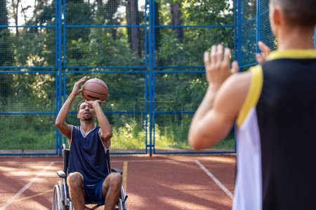 Photo for Wheelchair athlete and companion having a great time with energetic outdoor basketball - Royalty Free Image