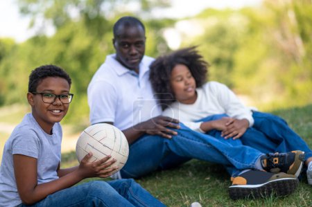 Téléchargez les photos : Week-end en famille. Mignon heureux afro-américain famille passer week-end dans le parc - en image libre de droit