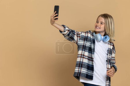 Téléchargez les photos : Selfie. sourire adolescent fille faire selfie et regarder apprécié - en image libre de droit