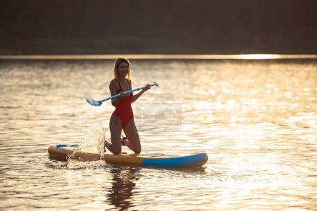 Foto de Mujer joven susurrando al amanecer en el río o lago. - Imagen libre de derechos