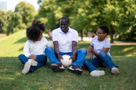 Téléchargez les photos : Week-end en famille. Mignon heureux afro-américain famille passer week-end dans le parc - en image libre de droit