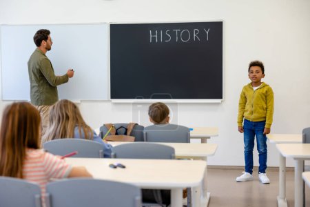 Photo for New comer. Teacher introducing a new boy to the classmates - Royalty Free Image
