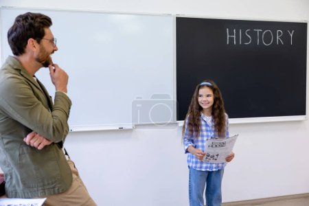 Photo for Giving an answer. The girl standing at the board at the lesson - Royalty Free Image