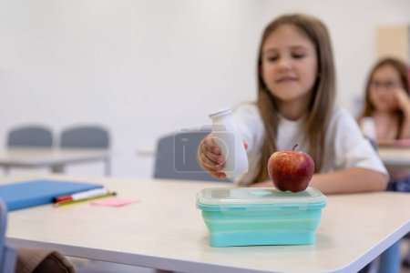 Photo for Lunch time. Cute long-haired girl having lunch at school - Royalty Free Image