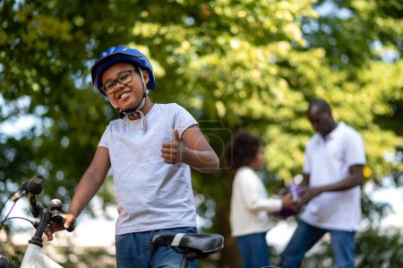 Photo for Ride in park. Kids spending time with dad and learning to ride a bike - Royalty Free Image