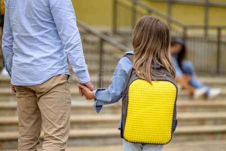 Foto de Mano a mano. Papá lleva a su hija a la escuela - Imagen libre de derechos