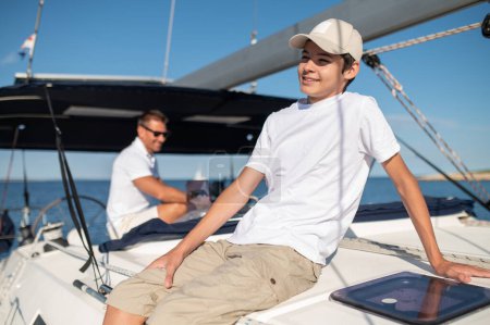 Photo for On the yacht. Dad and son on the yacht looking happy and cheerful - Royalty Free Image