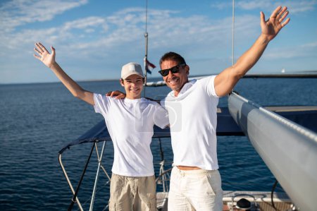 Téléchargez les photos : Sur le yacht. Papa et fils sur le yacht ont l'air heureux et joyeux - en image libre de droit