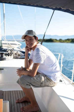 Photo for Leisure. Teen in white tshirt on yacht looking contented - Royalty Free Image