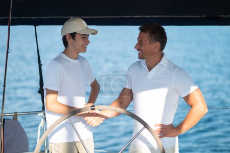 Photo for On a yacht. Dad and son spending time together on the yacht - Royalty Free Image