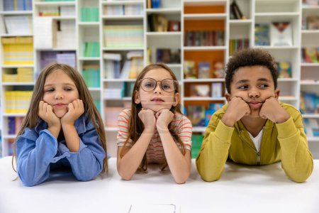 Photo for Classmates pupils posing in library or classroom in primary school. - Royalty Free Image