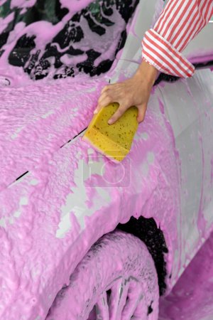 Photo for Car wash. Woman cleaning a white car the car wash - Royalty Free Image
