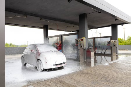Téléchargez les photos : Service de voiture. Femme travaillant à la voiture laver et laver la voiture - en image libre de droit