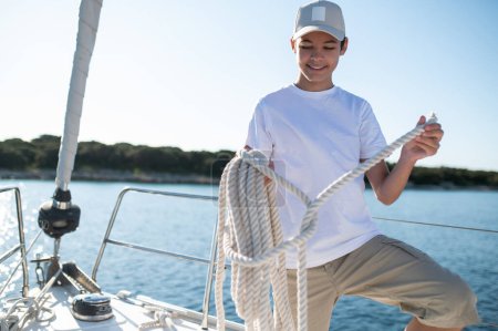 Téléchargez les photos : Journée ensoleillée sur un yacht. Père et fils naviguant sur le yacht par une journée ensoleillée - en image libre de droit