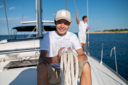 Photo for Sunny day. Mature man and his son on the yacht on a nice sunny day - Royalty Free Image
