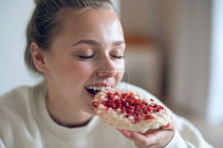 Photo for Breakfast. Close up of a girl eating sandwich and looking enjoyed - Royalty Free Image