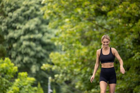 Téléchargez les photos : Heureuse femme gaie courir dans le parc d'été active sportive séance d'entraînement du matin. - en image libre de droit
