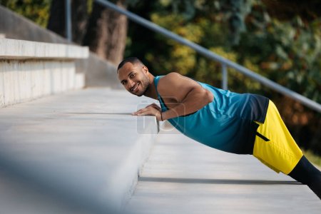 Foto de Haciendo ejercicio. Atleta de piel oscura bien parecido haciendo ejercicio en las escaleras - Imagen libre de derechos