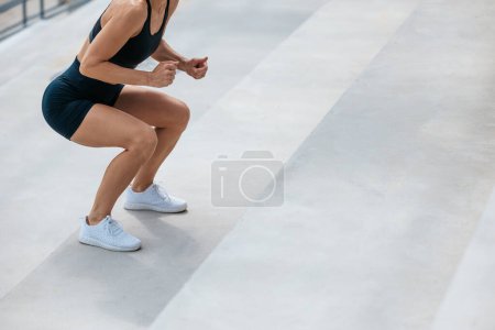 Téléchargez les photos : Des squats. Femme en short de sport noir faisant squats dans les escaliers - en image libre de droit