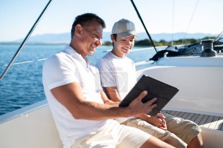 Photo for Happy times. Dad and son on the boat spending time together - Royalty Free Image