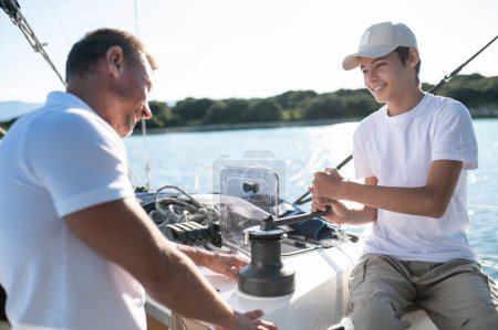 Photo for Leisure. Son and dad yachting and looking happy and contented - Royalty Free Image