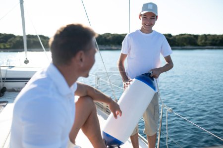 Photo for Leisure. Son and dad yachting and looking happy and contented - Royalty Free Image