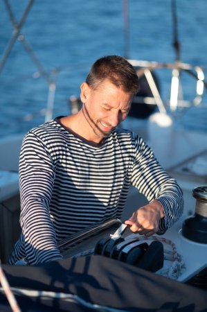 Téléchargez les photos : Voyage. Homme en chemise rayée sur un yacht se sentant bien - en image libre de droit