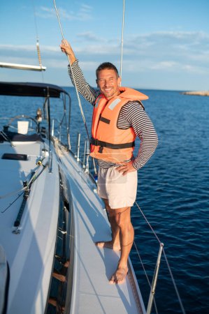 Photo for Sea trip. Man on a yacht smiling and feeling peaceful - Royalty Free Image