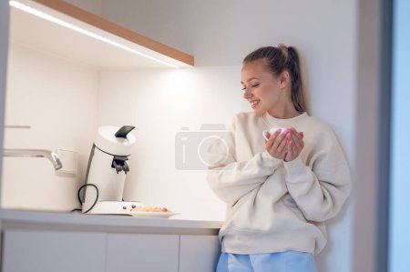 Foto de Hora del café. Sonriendo linda chica tomando café en la cocina - Imagen libre de derechos