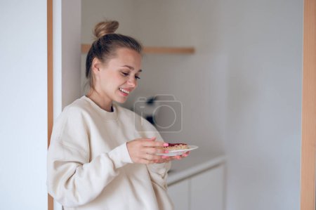Photo for Breakfast time. Young girl with the hair bun preparing breakfast for herself - Royalty Free Image