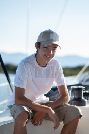 Photo for On a yacht. Smiling teen in a cap on a yacht - Royalty Free Image