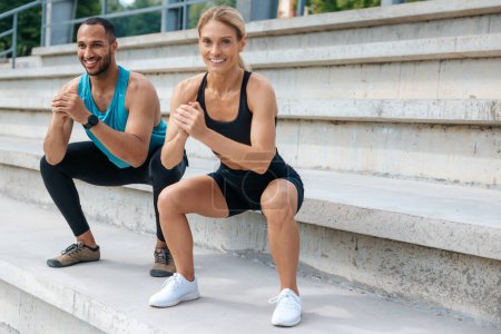 Photo for Healthy adult man and woman squatting on open air together. - Royalty Free Image