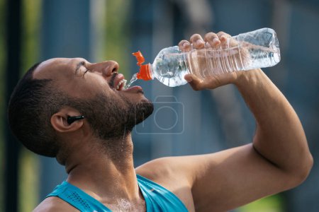Téléchargez les photos : J'ai soif. Sportsman se sentir assoiffé après l'entraînement et l'eau potable - en image libre de droit